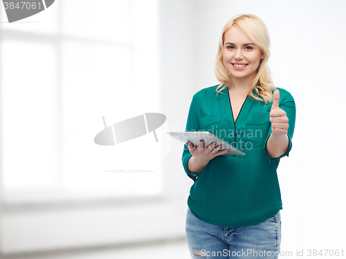 Image of smiling woman with tablet pc showing thumbs up