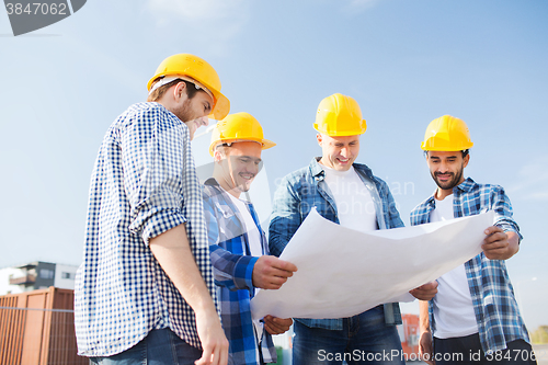 Image of group of builders with tablet pc and blueprint