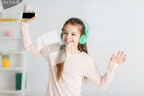 Image of girl with smartphone and headphones at home