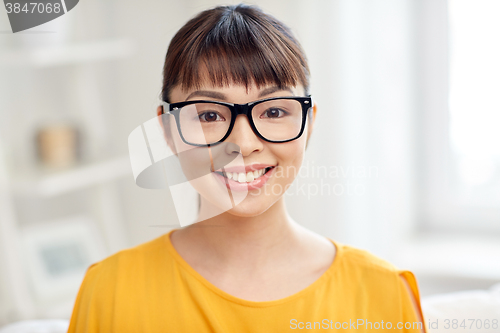 Image of happy asian young woman in glasses at home