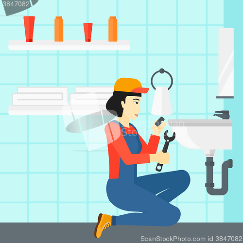 Image of Woman repairing sink.