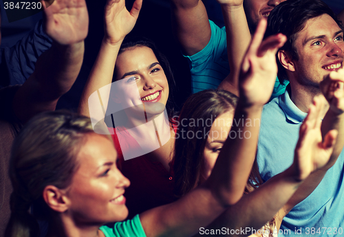 Image of smiling friends at concert in club