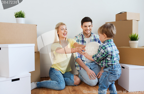 Image of happy family moving to new home and playing ball