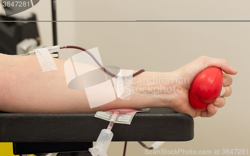 Image of Donor in an armchair donates blood,, close-up