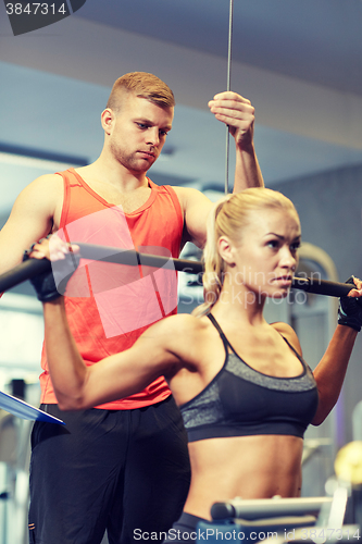 Image of man and woman flexing muscles on gym machine