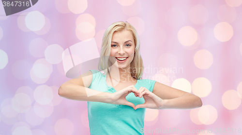 Image of happy woman or teen girl showing heart shape sigh