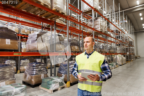 Image of manual worker with tablet pc at warehouse