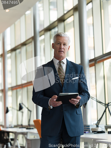 Image of senior business man working on tablet