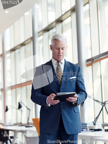 Image of senior business man working on tablet