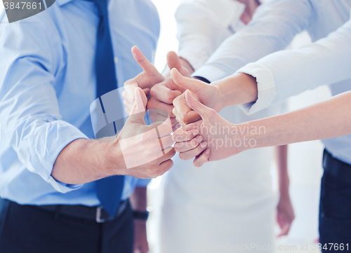 Image of business team showing thumbs up in office