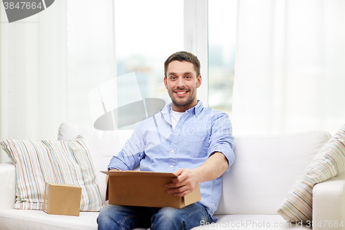 Image of happy man with cardboard boxes or parcels at home