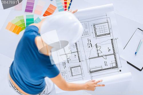 Image of woman with color samples and blueprint