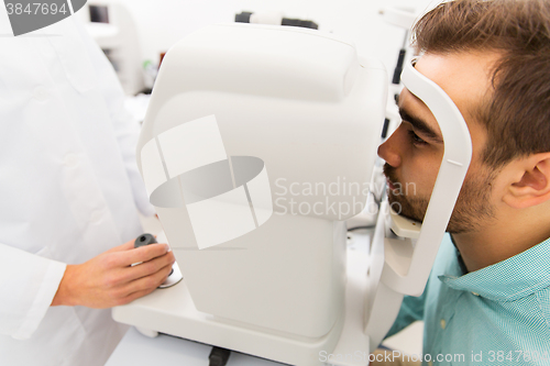Image of optician with autorefractor and patient at clinic