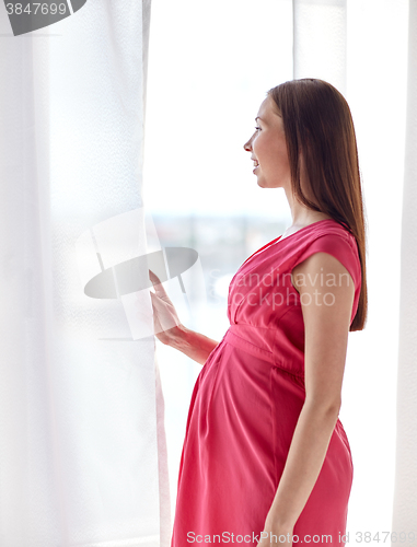 Image of happy pregnant woman with big tummy at home