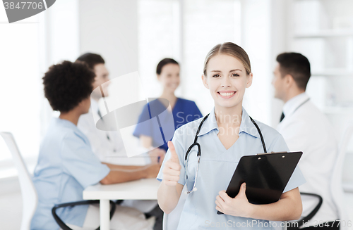 Image of happy doctor over group of medics at hospital