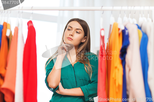 Image of woman choosing clothes at home wardrobe