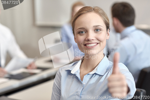 Image of group of smiling businesspeople meeting in office