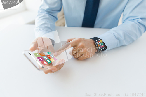 Image of close up of hands with smart phone and watch