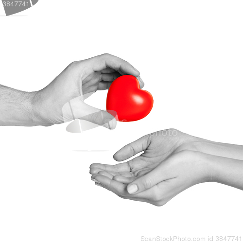 Image of man hand giving red heart to woman