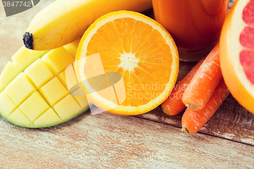 Image of close up of fresh fruits and juice glass on table
