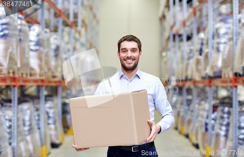 Image of happy man with cardboard parcel box at warehouse