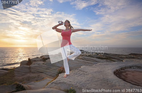 Image of Woman balance drinking wqter during exercise