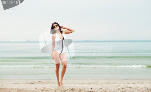 Image of young woman in swimsuit posing on beach