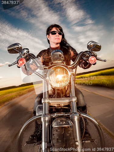 Image of Biker girl sitting on motorcycle