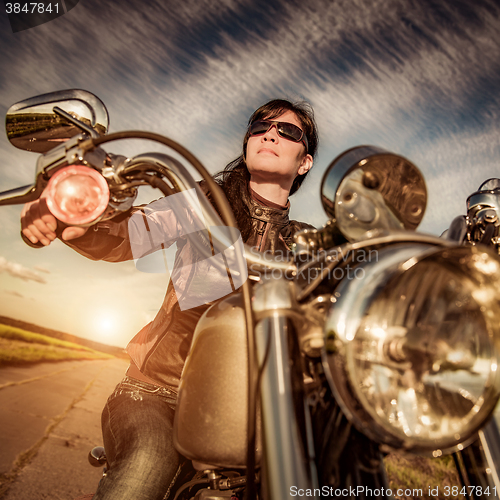 Image of Biker girl sitting on motorcycle