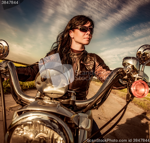 Image of Biker girl sitting on motorcycle