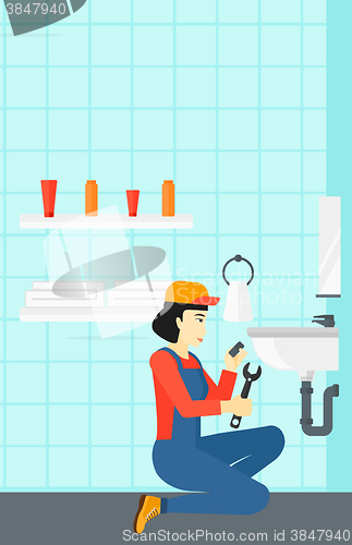 Image of Woman repairing sink.