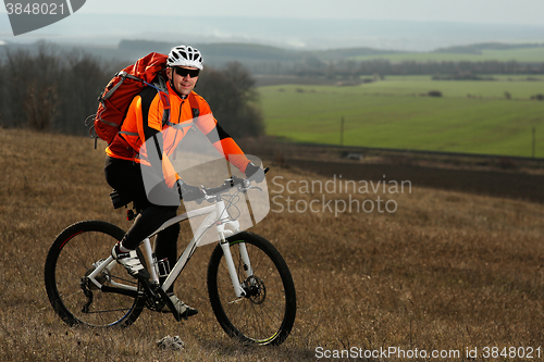 Image of Man cyclist with backpack riding the bicycle