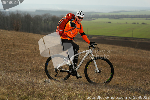 Image of Man cyclist with backpack riding the bicycle