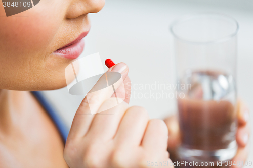 Image of close up of woman taking medicine in pill