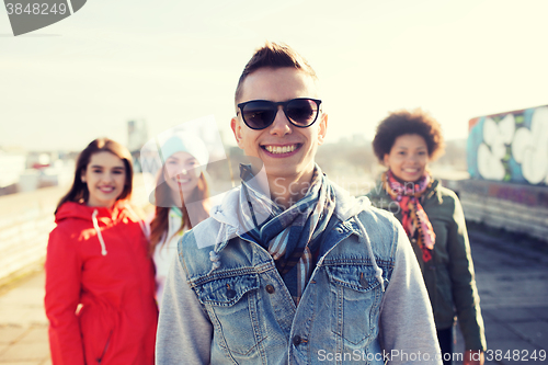 Image of group of happy teenage friends on city street