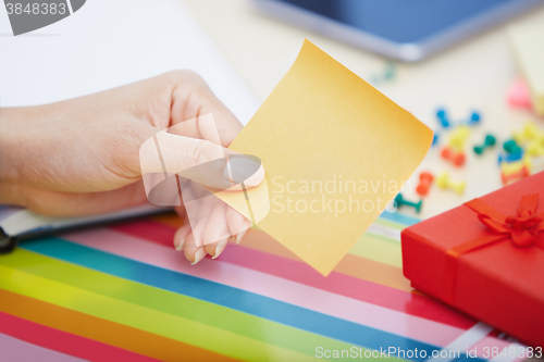 Image of Hand of woman with blank adhesive note