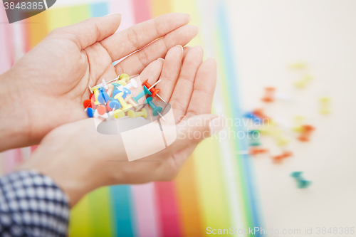 Image of Hands with colorful pushpins