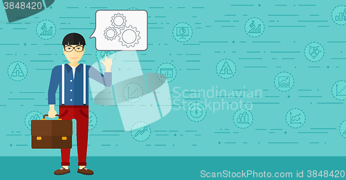 Image of Businessman pointing at cogwheels.