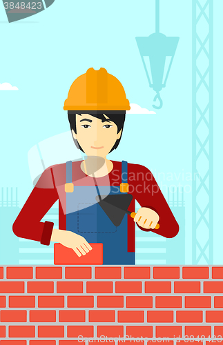 Image of Bricklayer with spatula and brick.