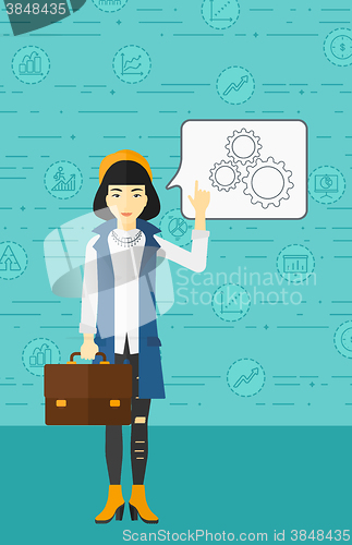 Image of Business woman pointing at cogwheels.