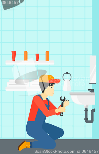 Image of Man repairing sink.