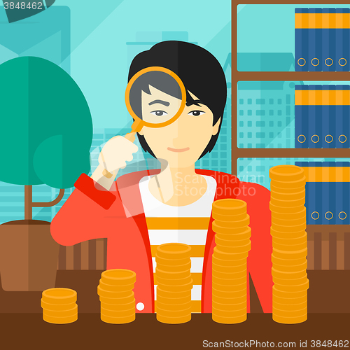 Image of Man with magnifier and golden coins. 