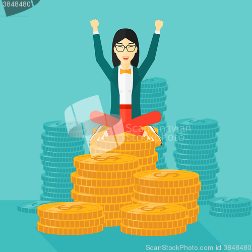 Image of  Happy business woman sitting on coins.