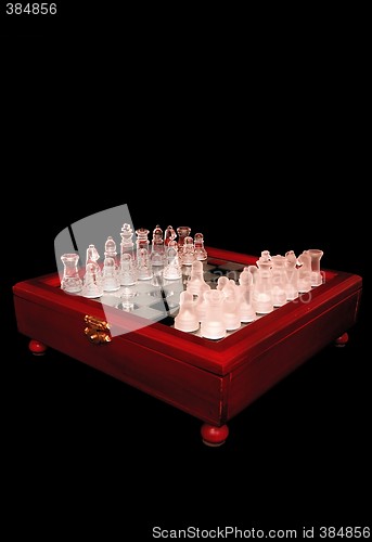 Image of Chess on a mirror wooden board, on a black background.