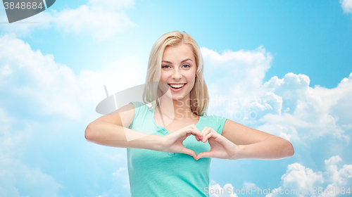 Image of happy woman or teen girl showing heart shape sigh