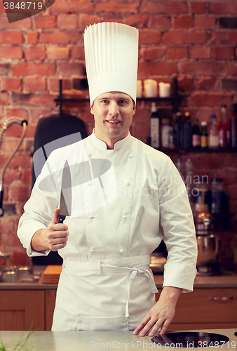 Image of happy male chef cook in kitchen with knife