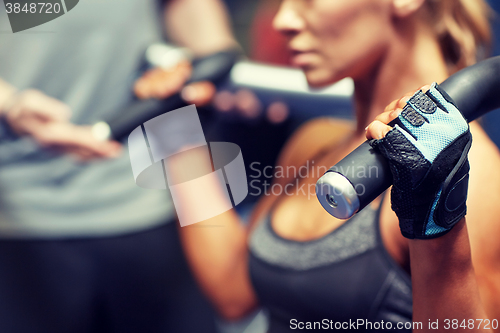 Image of man and woman flexing muscles on gym machine