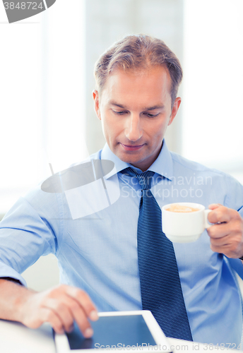 Image of businessman with tablet pc and coffee in office