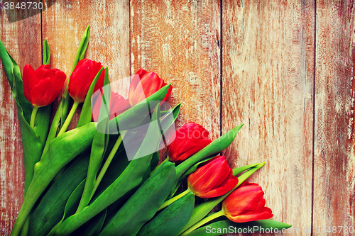 Image of close up of red tulips on wooden background