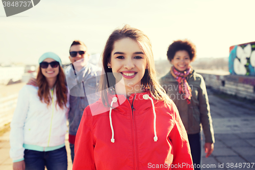 Image of group of happy teenage friends on city street